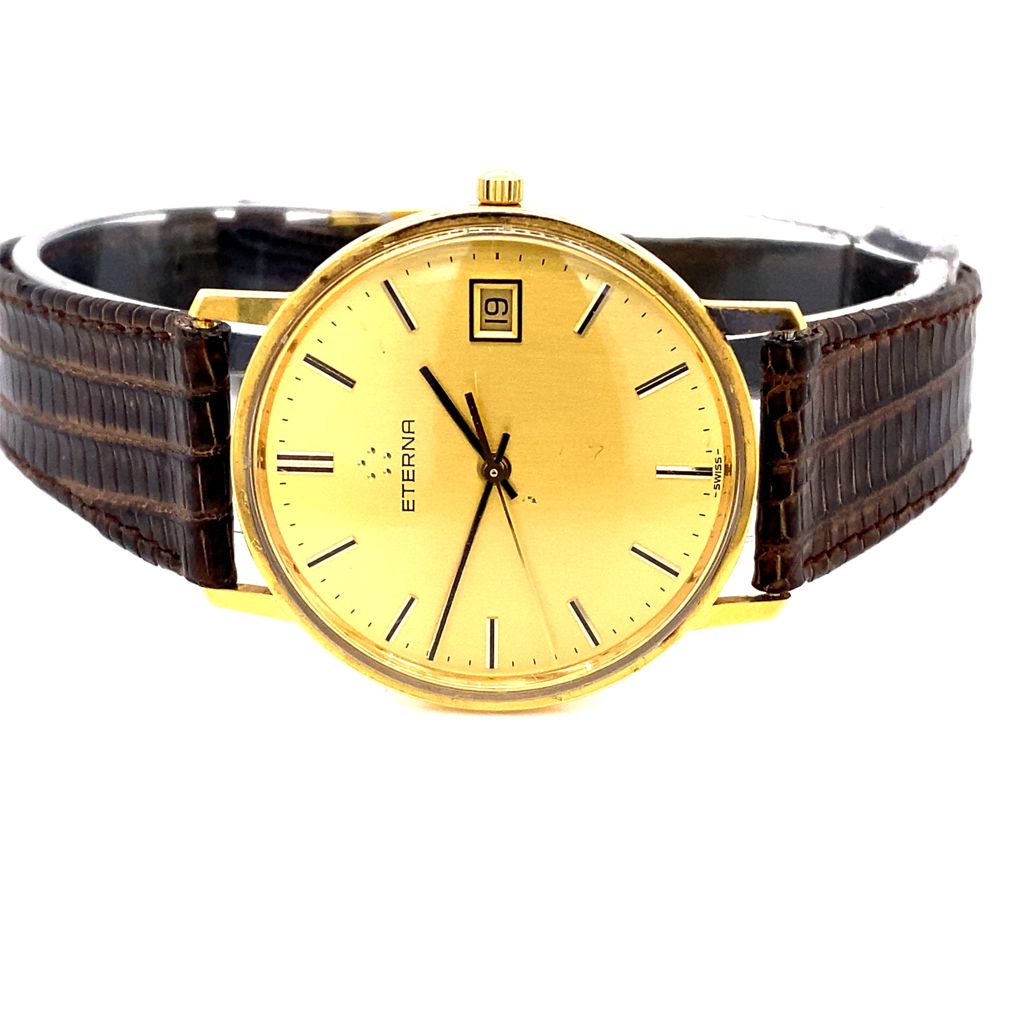 An image of a yellow metal Eterna quartz watch on a brown lizard strap, with its back cover removed to reveal the battery compartment. The image showcases the battery replacement procedure for the Eterna watch.